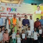 गुना में आयोजित रोजगार और स्वरोजगार कार्यक्रम में हितग्राहियों को लाभ वितरित करते अधिकारी