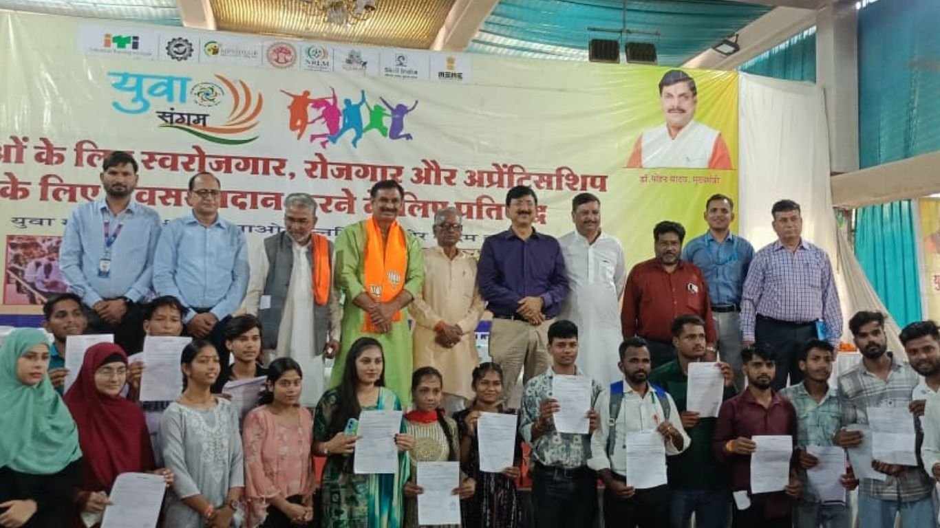 गुना में आयोजित रोजगार और स्वरोजगार कार्यक्रम में हितग्राहियों को लाभ वितरित करते अधिकारी